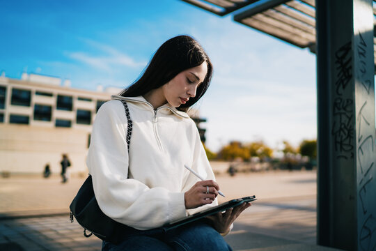 Portrait of focused woman typing message on smartphone at city bus stop, career growth, digital communication, modern technology, urban lifestyle, mobile banking, connectivity, street view.