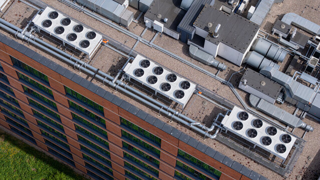 High angle aerial view of industrial HVAC units on an office building rooftop, modern ventilation and cooling system infrastructure.