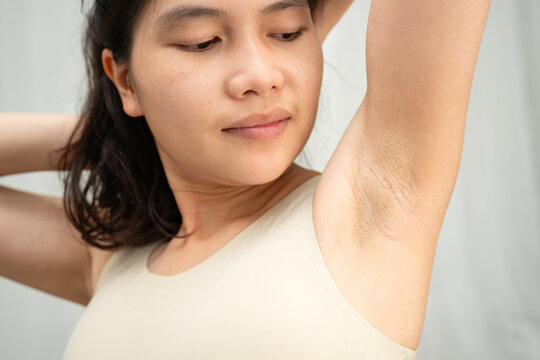Asian woman touching her neck and throat for thyroid gland problem.