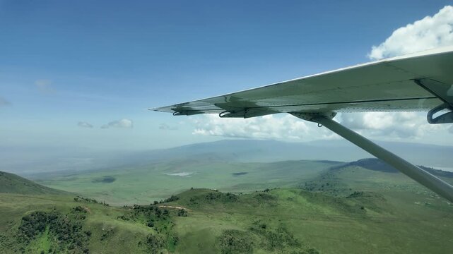 flying over lush green maasai land with rolling hills and villages after the rains