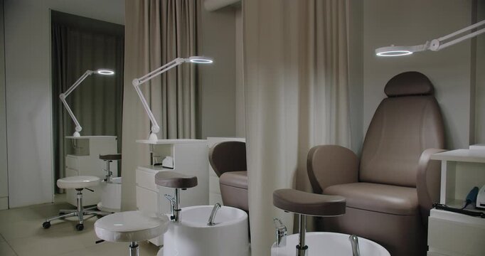 A contemporary nail salon featuring luxurious chairs, elegant decor, and bright, focused lighting for precision in beauty treatments. Modern Nail Salon Interior with Stylish Chairs and Bright Lights