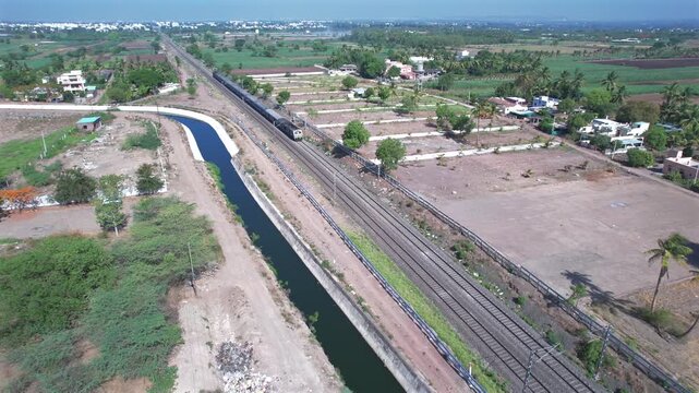 Aerial view of a local suburban commuter train in the countryside  near Pune India.