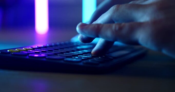 Slow Motion Of Hands Operating Audio Mixer And Computer Keyboard In Neon Studio, Music Production And Sound Engineering Concept
