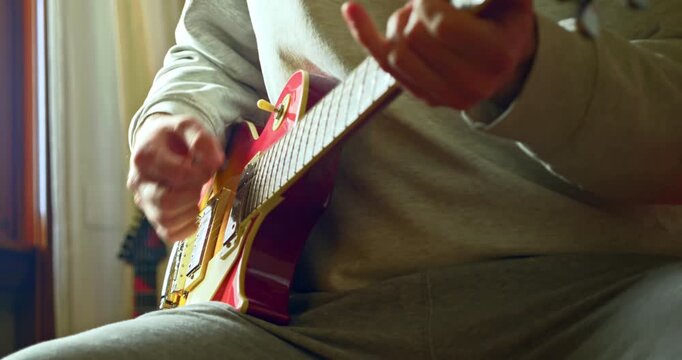 Slow Motion Close Up Of Hands Playing Electric Guitar In Warm Natural Light, Musician Practicing Instrument At Home