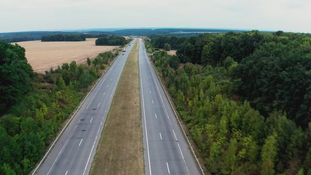 Long two-lane concrete road with traffic in rural area