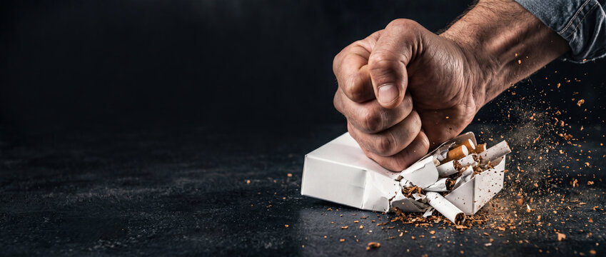 Strong hand crushing cigarettes pack. Quit smoking. World No Tobacco Day