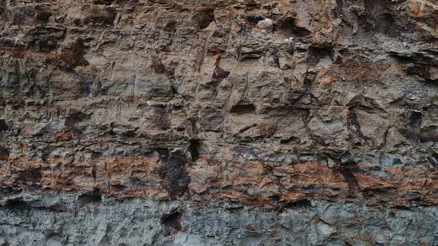 Natural soil stratification and eroded earth rock texture background. rugged surface features earthy tones.