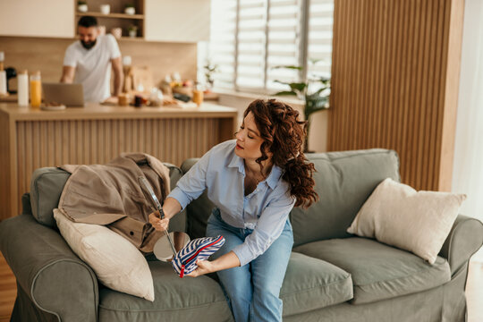 Woman doing makeup while man working in kitchen