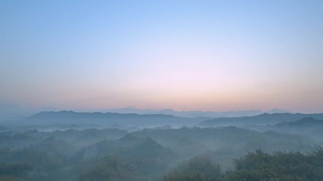 A breathtaking sunrise over the rolling hills and misty valleys of Zuozhen, Tainan, Taiwan, during a peaceful spring morning.