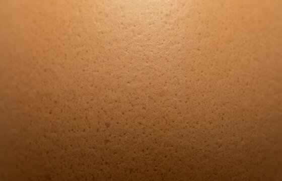 Extreme close-up of brown eggshell texture with natural speckles,Macro,A high-detailed macro shot revealing the intricate porous surface and organic brown patterns of a fresh chicken eggshell.