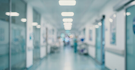 A blurred view of a hospital corridor, illustrating the busy, clinical environment often found in...