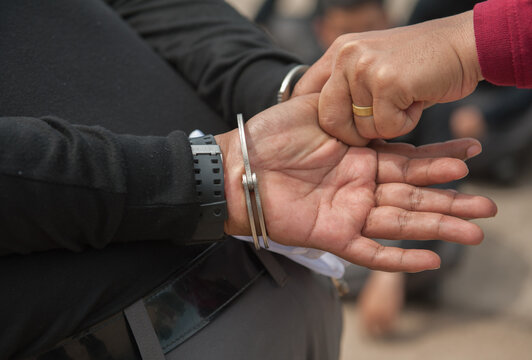 Police demonstrate how to use handcuffs to restrain suspects or prisoners.