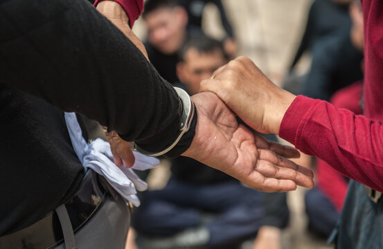 Police demonstrate how to use handcuffs to restrain suspects or prisoners.