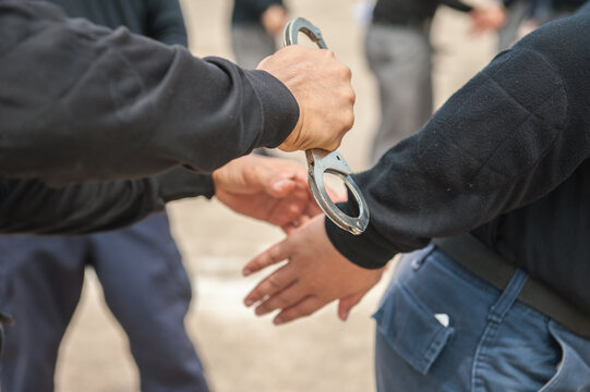 Police demonstrate how to use handcuffs to restrain suspects or prisoners.