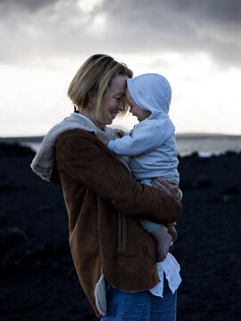 Authentic moment of love and connection between mother and toddler near the sea