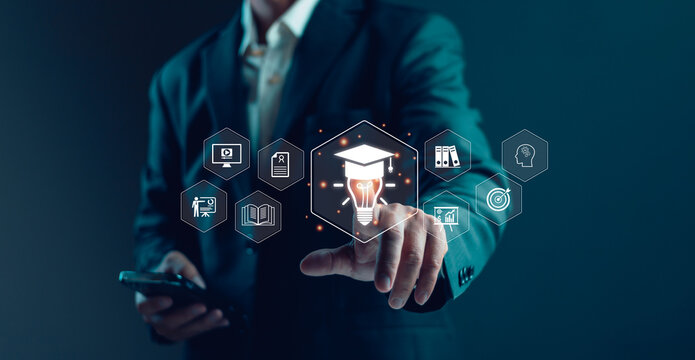 Businessman touching digital education technology interface with graduation cap, light bulb, online learning icons, knowledge management, innovation training and smart corporate development