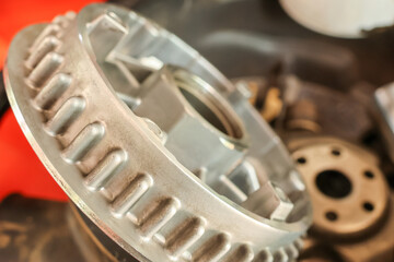 Naklejka premium Close up view of sturdy metal clutch basket engine part gear mechanical component during repair showing industrial reliable engineering power inside professional workshop garage setting