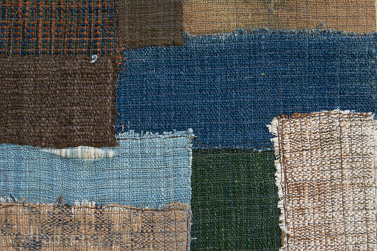 Top view of handmade cotton patchwork textile with layered traditional woven patterns.