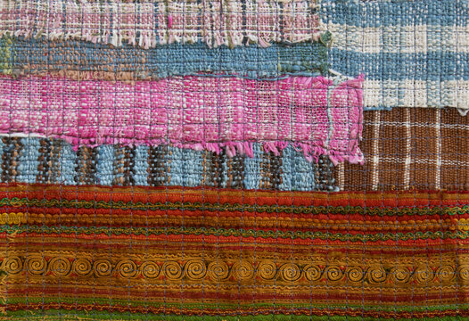 Top view of handmade cotton patchwork textile with layered traditional woven patterns.
