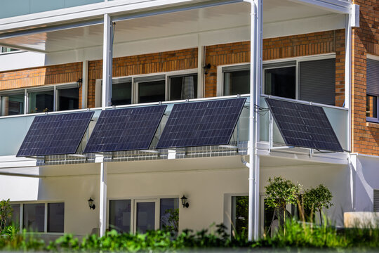 A balcony power plant with solar panels mounted on a residential building's railing