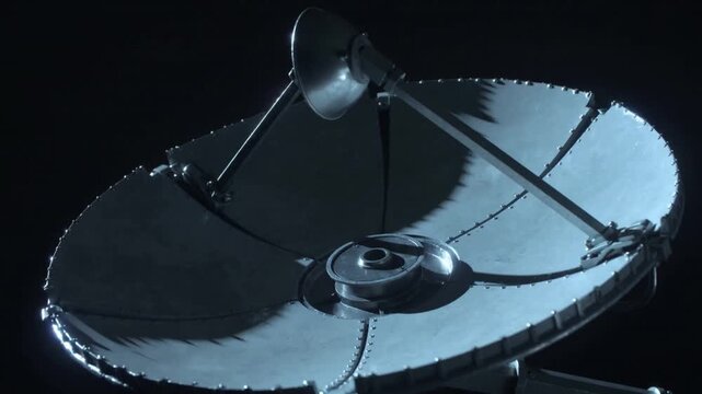 Tilting segmented parabolic dish shifting via mount in dark studio, revealing feed horn and rivets