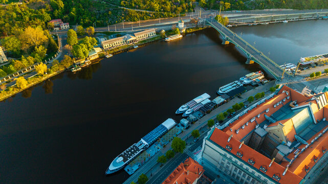 Aerial view of the Vltava River with cruise boats docked near the Stefanik Bridge and the Faculty of Law building in Prague, Prague, Czechia.