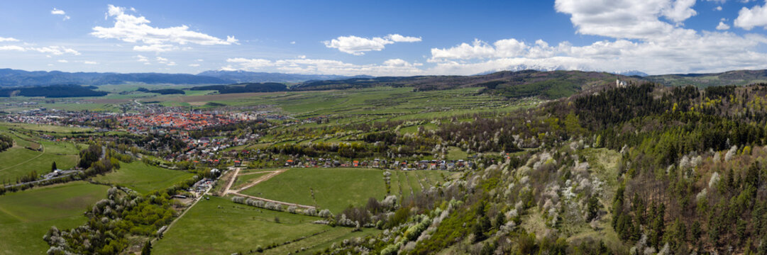 Ultra-wide aerial panoramic view of Levoca city, Marianska hora pilgrimage site, and the High Tatras mountains in spring, Slovakia