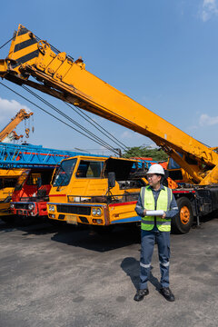 Crane safety inspection construction engineer maintenance Worker with clipboard during crane safety inspection construction yard checking lifting