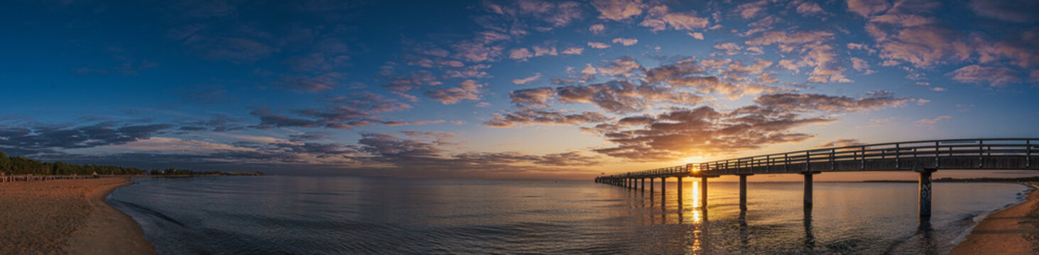 The pier in Boltenhagen on the Baltic Sea bathed in the warm light of sunrise.
