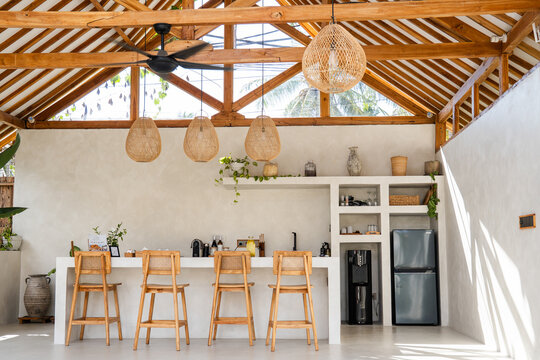 Stylish kitchen bar area with wicker lamps and exposed timber ceiling in a relaxed setting