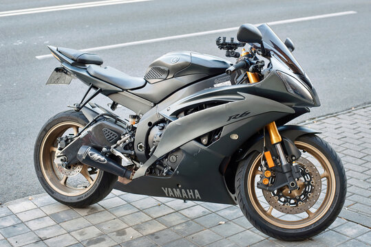 Minsk, Belarus. Sep 6, 2025. Yamaha R6 sportbike parked on street. Matte grey Yamaha R6 sport bike, high performance motorcycle, gold rims and custom exhaust system, street bike resting on sidewalk