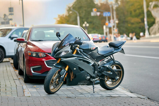 Minsk, Belarus. Sep 6, 2025. Matte grey Yamaha R6 sportbike. Sleek matte grey Yamaha R6 sportbike is parked on paved sidewalk on sunny city street with traffic lights and green trees in the background