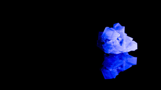 Fluorescent fluorite crystal under UV light on black background with reflection