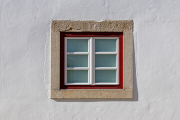 Fototapeta premium Traditional Portuguese window with red frame in Tomar