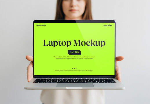 A woman holding a laptop in front of her for a mockup