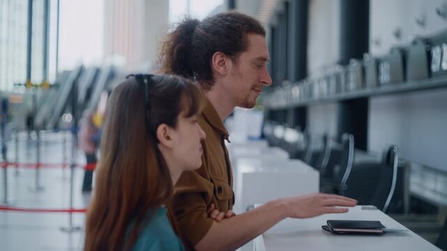 Young travelers giving their travel documents to an airport agent before their flight