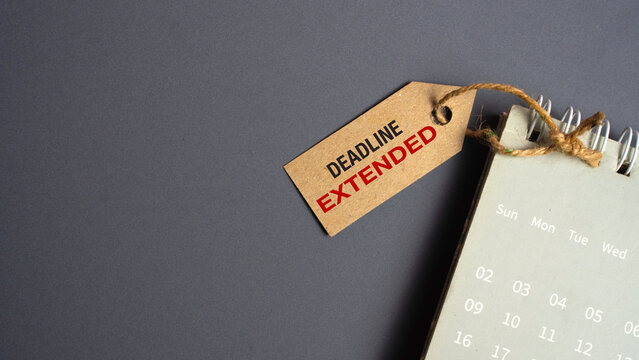 Deadline Extended Text on Brown Paper Tag Attached to a Calendar Representing Time Management and Project Extension Concepts
