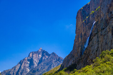 Fototapeta premium Majestic cliffs with waterfall and lush vegetation
