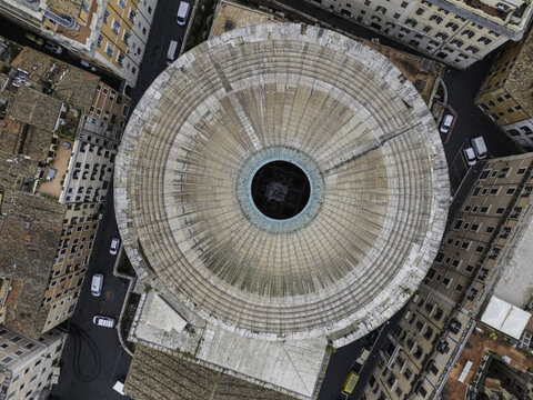 Aerial view of the Pantheon's iconic dome and oculus surrounded by historic rooftops and narrow streets in Rome, Lazio, Italy.