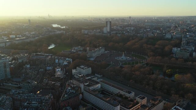 Golden hour illuminating Buckingham Palace gardens, Hyde Park, Serpentine lake, Green Park, and the city of London