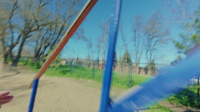 The dog runs back and forth across the high bridge at the command of the owner. An intelligent dog is trained on a dog playground. A little dog. From the first person.