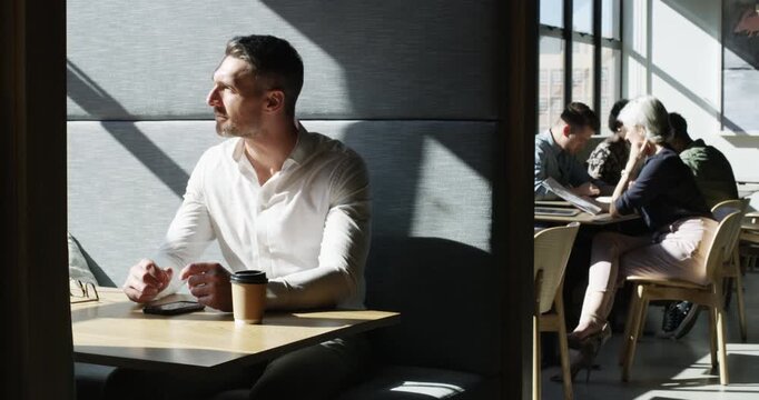 Businessman, thinking and smartphone for texting, cafe or communication in modern office. Face, male person and idea with vision for corporate plan, coworking space and future with online analytics