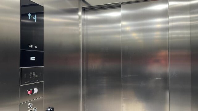 Interior of modern stainless steel elevator with closed doors and digital floor indicator, minimal architecture, everyday movement in office environment, transport and urban lifestyle concept