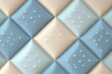 Naklejka premium A luxurious quilted pattern featuring soft light blue and cream diamond shaped panels with small pearls