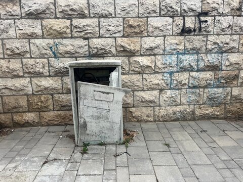old stone wall behind a broken box in the middle of the city