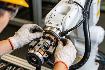 Fototapeta premium Technician in safety helmet and gloves meticulously assembling a robotic arm component
