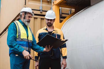Industrial engineers discussing logistics and tank container maintenance. Senior caucasian worker...