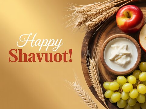 Happy shavuot greeting card with wheat stalks, fresh apple, grapes and a bowl of dairy cream on a wooden plate