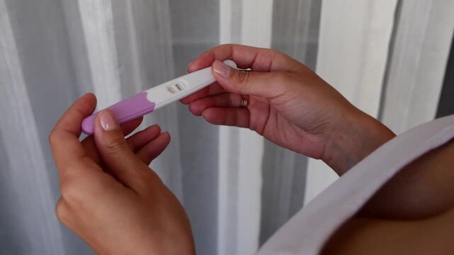 Negative home pregnancy test in woman hands, one line result, not pregnant, trying to conceive, family planning, fertility awareness.