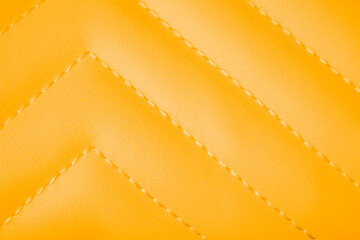 Fototapeta premium Vivid orange yellow quilted faux leather texture with elegant diagonal stitching patterned background